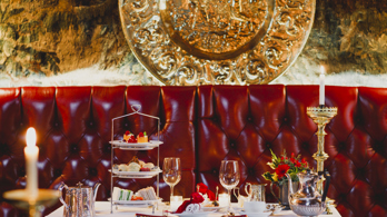 Elegant dining room at The Witchery with candlelit tables set with gourmet dishes and rich décor