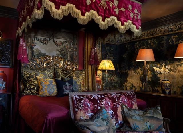 Antique tapestry walls and decadent velvet gothic bed, in The Turret luxury hotel suite at The Witchery.